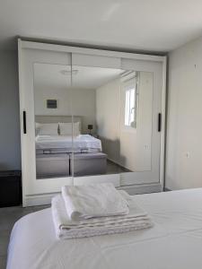 een witte slaapkamer met een spiegel en een bed bij Ethos Apartment 2 in Néa Péramos