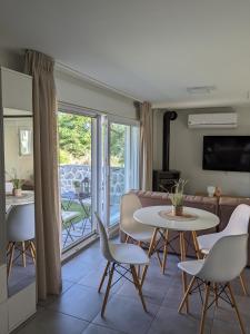 ein Wohnzimmer mit einem Sofa, einem Tisch und Stühlen in der Unterkunft Ethos Apartment 2 in Néa Péramos