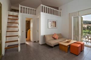 a living room with a loft bed and a couch at Iro Suites in Andros