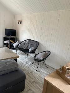 a living room with two chairs and a couch at Chalet rénové Cabourg in Cabourg