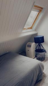 een slaapkamer op zolder met een bed en een raam bij Chalet rénové Cabourg in Cabourg