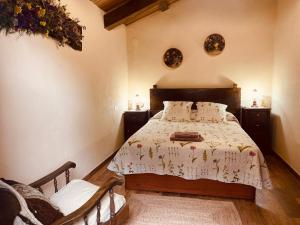 a bedroom with a bed and two tables and a chair at Casa da Costa de Sueiro in Sueiro