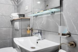 een witte badkamer met een wastafel en een toilet bij Apartmani LIVAJA in Plano +100 foto's