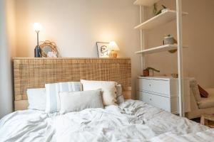 um quarto com uma cama branca e uma cadeira em Beautiful central apartment steps from lake and water jet em Genebra