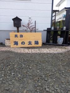 uma placa de madeira com escrita chinesa em frente a um edifício em Abashirikai no Taiyo - Vacation STAY 14557 em Abashiri