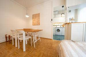cocina y comedor con mesa y sillas en Beautiful central apartment steps from lake and water jet en Ginebra
