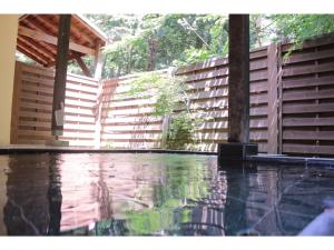 a swimming pool in front of a wooden fence at Gusthof Lumiere - Vacation STAY 41349v in Fujikawaguchiko