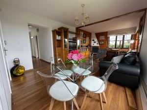 ein Wohnzimmer mit einem Glastisch und Stühlen in der Unterkunft CHALET ENTRE DOS PLAYAS TAPIA in Tapia de Casariego