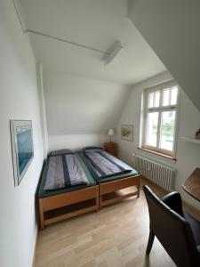 ein Schlafzimmer mit einem Bett und einem Stuhl darin in der Unterkunft Charmante Altbauwohnung am Rhein in Basel