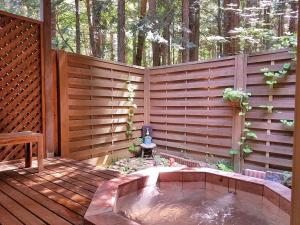 a wooden privacy fence with a hot tub on a deck at Gusthof Lumiere - Vacation STAY 41339v in Fujikawaguchiko