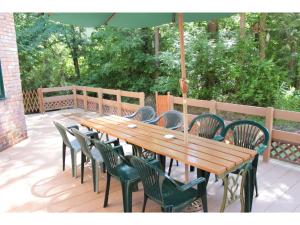 - une table et des chaises en bois avec un parasol sur la terrasse dans l'établissement Gusthof Lumiere - Vacation STAY 41353v, à Fujikawaguchiko