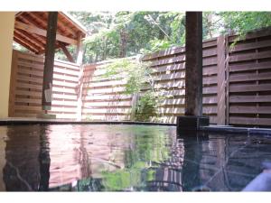 a swimming pool in front of a wooden fence at Gusthof Lumiere - Vacation STAY 41353v in Fujikawaguchiko