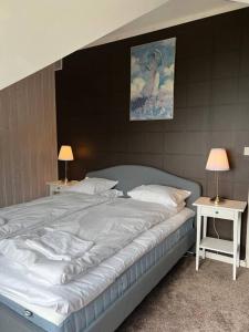 a large white bed with two tables and two lamps at Moldegaard Farmhouse - Apartment C in Moldegard