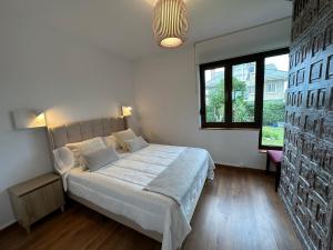 ein Schlafzimmer mit einem großen Bett und einem großen Fenster in der Unterkunft CHALET ENTRE DOS PLAYAS TAPIA in Tapia de Casariego