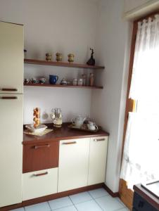 a kitchen with white cabinets and shelves in a room at CRISTIN B&B in Monfalcone