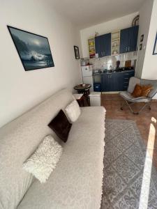 ein Wohnzimmer mit einem weißen Sofa und einer Küche in der Unterkunft Milinovic apartmani1 in Herceg-Novi