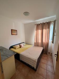 ein kleines Schlafzimmer mit einem Bett und einem Fenster in der Unterkunft Milinovic apartmani1 in Herceg-Novi