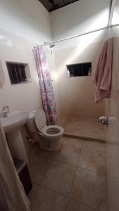 a bathroom with a toilet and a sink and a shower at Fresca casa de descanso en La Jagua in Garzón
