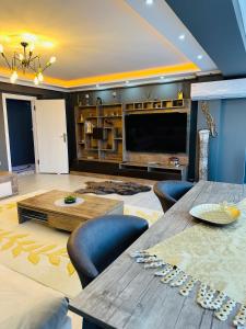 un ampio soggiorno con tavolo e TV di Akhome - Luxury dublex apartment a Çanakkale