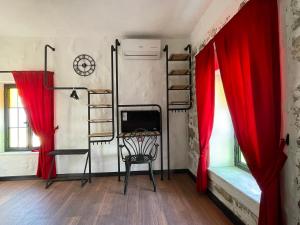 een kamer met 2 stapelbedden en rode gordijnen bij Romalı Guesthouse in Ayvalık
