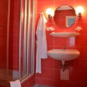 a red bathroom with a sink and a mirror at Haus Gaia in Frauenstein