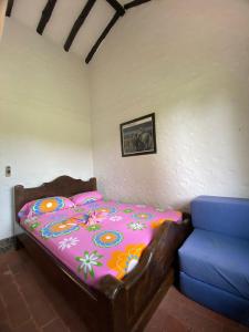 ein Schlafzimmer mit einem Bett und einem blauen Sofa in der Unterkunft CASA CAMPESTRE LA CAMPIÑA LA VICTORIA Valle del Cauca ESPACIO COMPLETO-desayuno a pareja in Matazarza