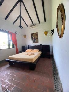 1 dormitorio con cama y espejo en la pared en CASA CAMPESTRE LA CAMPIÑA LA VICTORIA Valle del Cauca ESPACIO COMPLETO-desayuno a pareja, en Matazarza