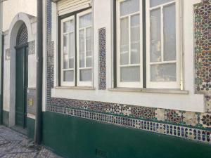 um edifício com duas janelas e uma porta verde em Casa da Genoveva - Typical House em Aveiro mais 38 fotografias