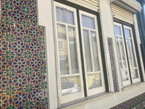 un grupo de ventanas en un edificio con patrones en él en Casa da Genoveva - Typical House, en Aveiro