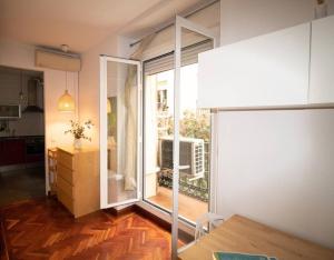 un soggiorno con una grande porta a vetri che conduce a una cucina di Exclusivo y acogedor Apartamento en Chueca, Madrid a Madrid