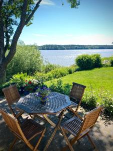een picknicktafel met 2 stoelen en een meer bij Private lakefront property in Söderköping