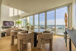 a dining room with a table and chairs and a large window at @ Marbella Lane - Penthouse w/ City & Ocean Views in Long Beach
