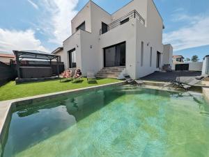 una casa con piscina delante de una casa en Le Petit Dubaï, en Saint-Jean-Lasseille