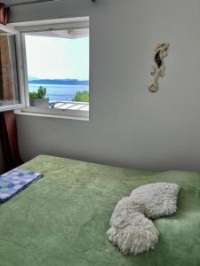 a bedroom with a green bed with a window at Milinovic apartmani3 in Herceg-Novi