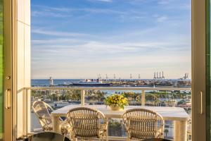 a balcony with a table and chairs and a view of the ocean at @ Marbella Lane - Penthouse w/ City & Ocean Views in Long Beach