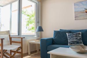 a living room with a blue couch and a table at Andreas House in Lixouri