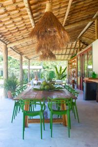 a table with green chairs and a ceiling at Pousada Rancho Luar in Pôrto de Pedras