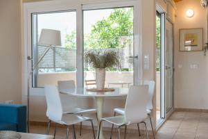 a dining room with a table and white chairs at Andreas House in Lixouri +31 photos