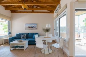 a living room with a blue couch and a table at Andreas House in Lixouri