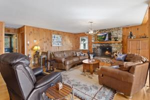 a living room with leather furniture and a fireplace at Golden Ridge Getaway in Blowing Rock