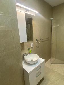 a bathroom with a white sink and a shower at Good Vibes Apartment in Oradea +29 photos