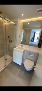 y baño con aseo, lavabo y ducha. en Ardwyn Studio Apartments Gibraltar en Gibraltar