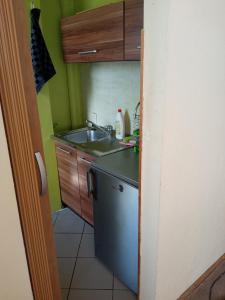 a small kitchen with a sink and a dishwasher at Kawalerka blisko morza in Gdańsk