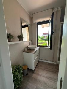 ein Badezimmer mit Waschbecken und Fenster in der Unterkunft CHALET ENTRE DOS PLAYAS TAPIA in Tapia de Casariego + 19 Fotos