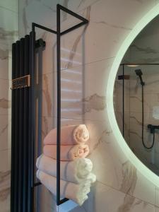 un estante de toallas en un baño con espejo en Cienista Dolina 