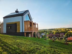 a house on top of a grassy hill at Cienista Dolina in Brzoskwinia
