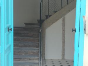 uma porta que conduz a uma escada com uma escada em Studio Cosy en centre ville em Arpajon