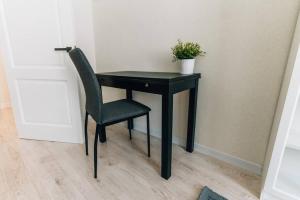 Un escritorio negro con una silla y una planta. en Rigas street cozy apartment, city centre en Daugavpils