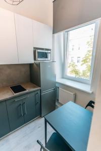 a small kitchen with a blue table and a window at Rigas street cozy apartment, city centre in Daugavpils