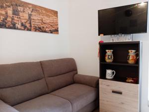 a living room with a couch and a flat screen tv at La Dimora di Pietra in Gubbio
